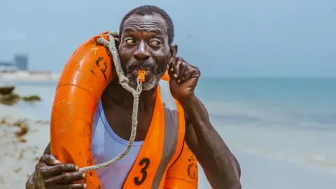 BBC Lifeguard Nicholas Paul whistling on the beach in Lagos, Nigeria