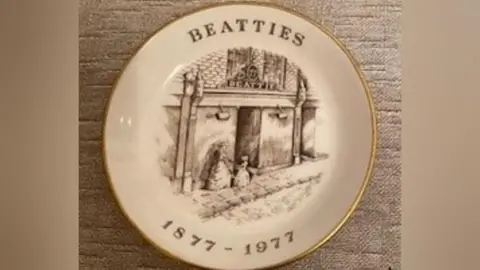 Jane Gynn place embossed with black and white drawing of beatties store