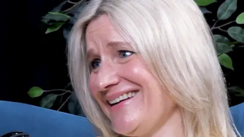 A woman with blonde hair smiling.