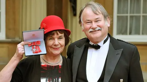 Gruffalo author Julia Donaldson poses with her husband Malcolm outside Buckingham Palace after she was awarded and MBE