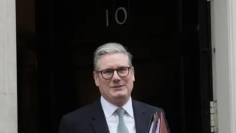 Sir Keir Starmer stands outside 10 Downing Street on his way to Prime Minister's Questions, holding a couple of red folders