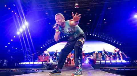 Getty Images Chris Martin standing on a stage 