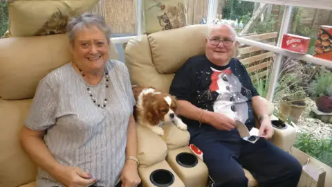Denise Scott Paulette Crookes and her husband James sat with their dog between them on a cream sofa