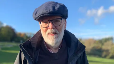 BBC John Bloxsom looking at the camera while standing outside