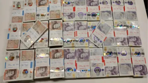 West Midlands Police The cash found by police in a car boot in Hockley