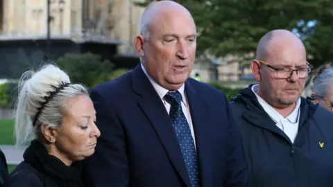 PA Media Harry Dunn's parents with their solicitor