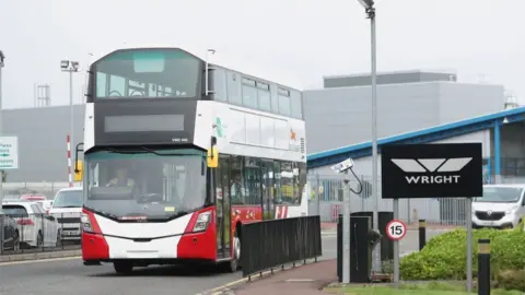 PA Media A completed Bus Eireann bus leaves the Wrightbus plant in Ballymena, Northern Ireland