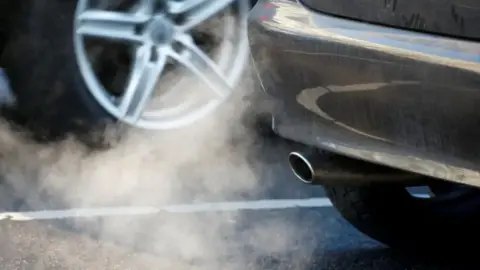 A picture of a car with fuel pouring out of its exhaust pipe.