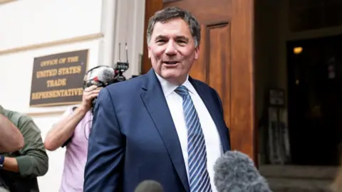 Dominic LeBlanc, in a suit and tie, speaks to reporters as he stands outside the doors to the US trade representative's office