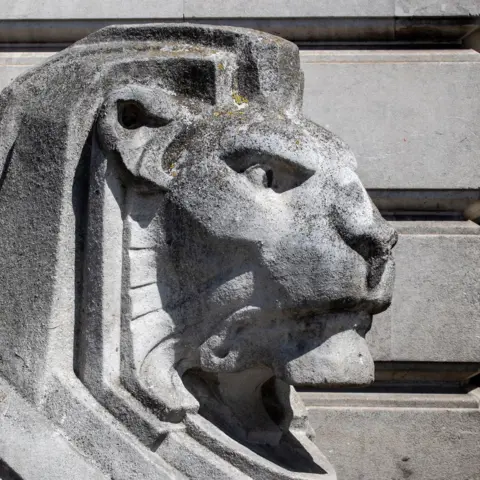 Getty Images A close up of a lion statue head with patches of dark where the weather has taken its toll