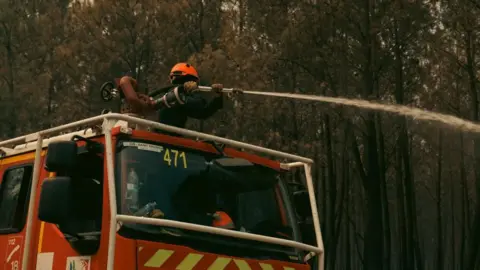 A firefighting crew is deployed to battle a wildfire in Saint-Jean-d'Illac, southwestern France.