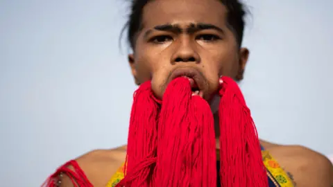 AFP Performer with strings running across his pierced cheeks