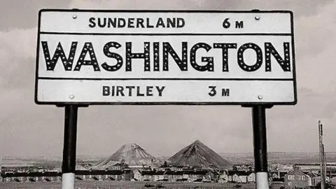 Raggy Spelk A Washington sign with the colliery behind, coal spoil heaps rising in the background.