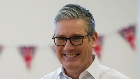 Prime Minister Sir Keir Starmer smiles during a meeting with locals at a community centre in Hertfordshire.