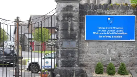 A car wrapped in black plastic and a garda car at the scene at Renmore Barracks in County Galway, after an army chaplain was stabbed