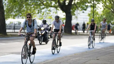 Aaron Chown/PA Media People cycling in Chelsea, London, UK