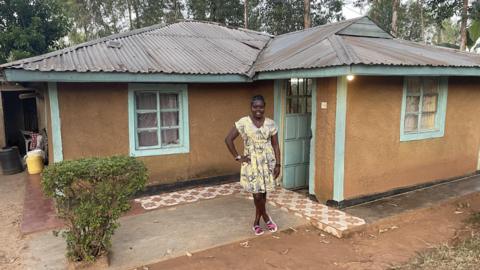 Grace Ashenga stood by her family home in Nairobi
