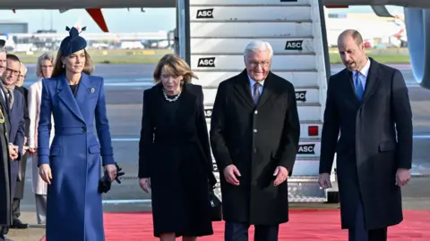 Reuters Catherine and William walk in a line with the German president and his wife down a red carpet stretched out on the tarmac, with the stairs up to an aeroplane behind them