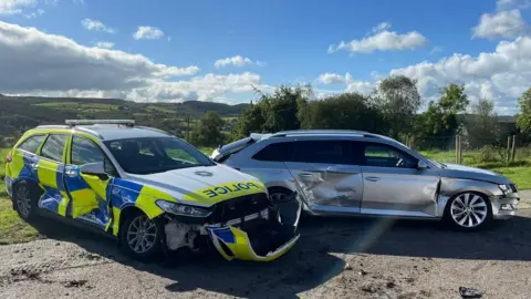 PSNI Police cars showing damage after being rammed by tractor