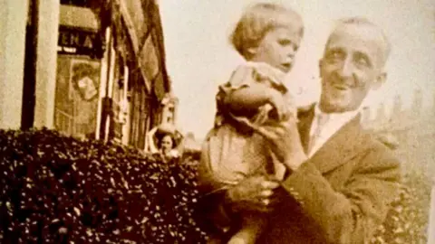 Greaves family A sepia image of a man holding a young child.