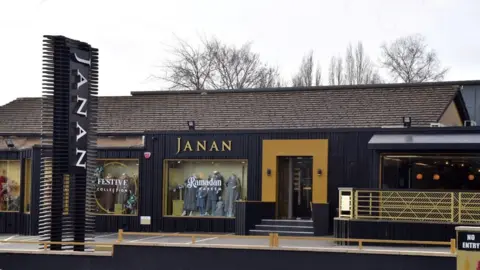 The exterior of Janan, with a large sign at the entrance and a number of window displays including one with writing saying 'Ramadan Kareem' on the window and another featuring the words 'festive collection'. 