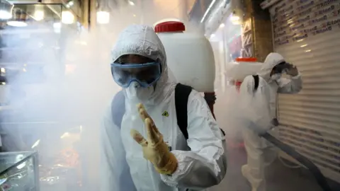 Getty Images Firefighters disinfect the Tajrish Bazaar, Tehran, Iran