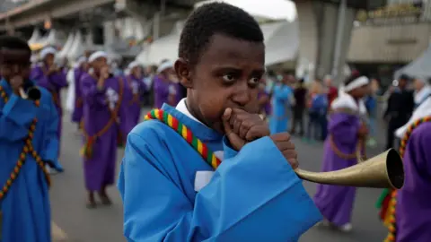 Reuters A choir member blows a traditional trumpet during the Meskel Festival