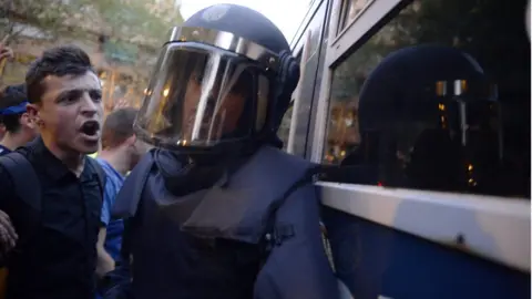 AFP A protester confronts a Spanish policeman in Barcelona, 20 September