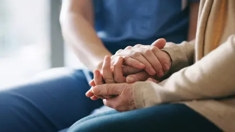 Getty Images Care worker and patent hands