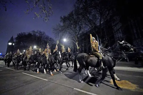 PA Media Members of the military outside Westminster Abbey, central London, during a night time rehearsal for the coronation of King Charles III on 18 April 2023