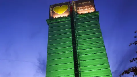 PA Media File photo dated October 2019 of the Grenfell Tower illuminated with green lighting