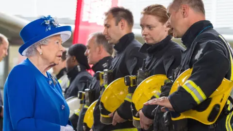 PA Media Queen Elizabeth II meets firefighters during a visit to the Westway Sports Centre, London, which is providing temporary shelter for those who have been made homeless by the fire at Grenfell Tower