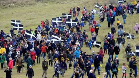 St Piran One and All Crowd marching at Perran Sands
