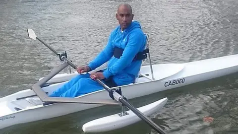 IAN BARRINGTON Ian Barrington in his rowing boat He is wearing a light blue tracksuit