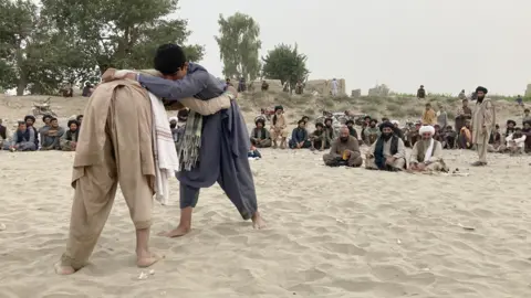 BBC Two young boys wrestling each other as spectators watch