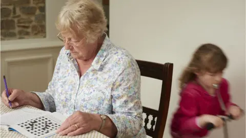 Getty Images Woman doing crossword puzzle