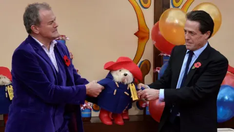 Reuters Left-right: Hugh Bonneville, Paddington, Hugh Grant