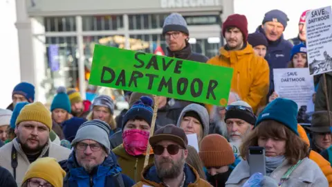 Martin Hampton Protest with protestor holding up sign saying Save Dartmoor