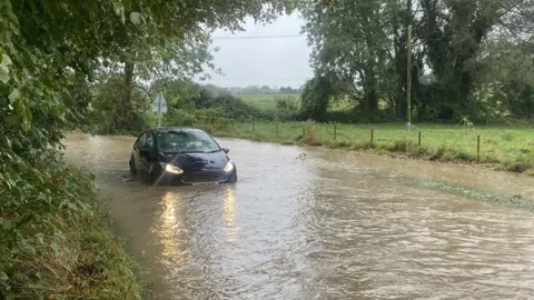 Car in flooded road in Flowton