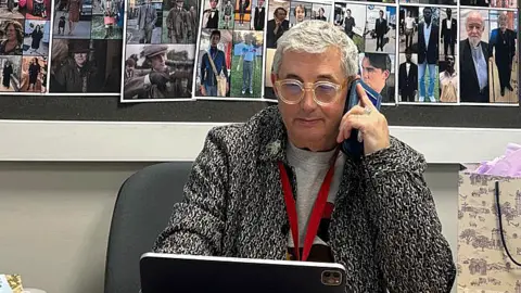 Ray Holman Ray Holman sitting at a desk and holding a phone to his ear