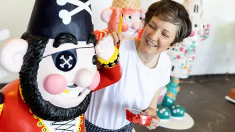Gromit Unleashed/Barbara Evripidou Artist Paula Bowles paints her Norbot sculpture which will be part of the Gromit Unleashed Trail in Bristol this summer. She is painting hers in the style of a pirate with a red jacket and black beard.