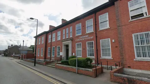 Google A red-brick building with white lettering above the ground floor windows which reads Cheshire Coroner's Court. There is a lamppost on the pavement in front of the building and a set of steps leading up to the front door as well as a ramp to the right hand side of the building.