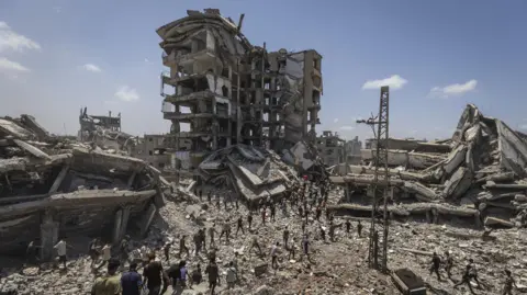 Anadolu via Getty Images Planes drop aid packages by parachute amid Israeli attacks as the Palestinians flock to the area where the humanitarian aid packages land over western Gaza City, Gaza on August 7, 2025. 
