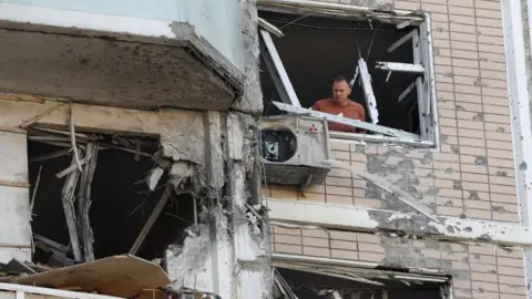 A man inspects a damaged apartment building following a Ukrainian drone attack in the Moscow region, Russia. Photo: 17 May 2026