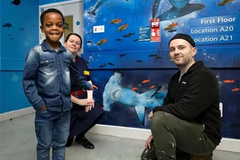 The Royal Wolverhampton NHS Trust Noah Sessi, aged five, Sarah Lewis, matron, and Daniel Russell-Ahern