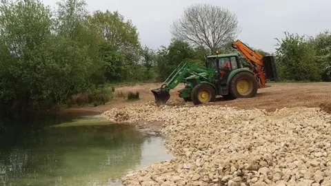 North Lincs Council digger laying stones at waterside