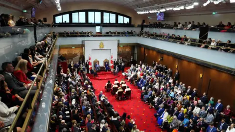 Reuters People gathered in the building the Senate is currently using, which was once Ottawa's main rail station. It has a bright red carpet.