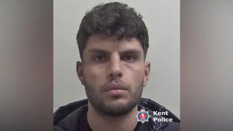Kent Police A man with dark hair and a beard.