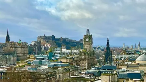 View over Edinburgh city with blue sky and clouds above