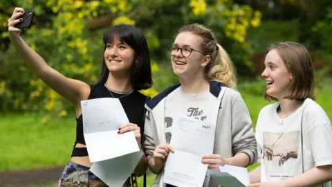 Getty Images Students pose for a photograph with their A Level results at Ffynone House School in Swansea